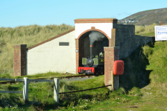 Fairbourne-steam-train-emerging-from-a-tunnel-editorial